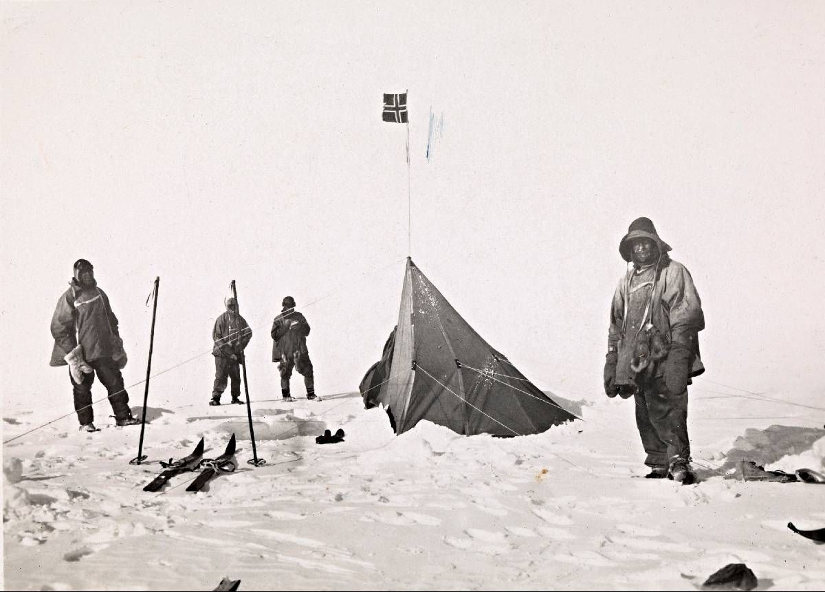 Historisk Amundsen-ekspedisjon ved telt og norsk flagg i snølandskap